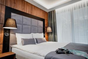 斯蒂格纳Bursztynowe Resort&SPA Stegna的一间卧室配有一张大床和大床头板