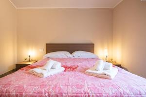 帕尔马G12 Double Rooms l Zona Ospedale Centro l Parking Custodito Privato的一间卧室配有粉红色的床和毛巾