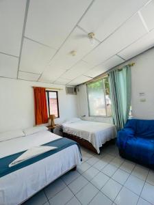 阿约拉港Hostal Darwin B&B的一间卧室配有两张床和蓝色的沙发