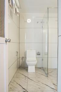 瓦尔卡拉Avanthi Homestay的一间带卫生间和玻璃淋浴间的浴室