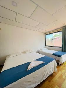 阿约拉港Hostal Darwin B&B的带窗户的客房内的两张床