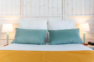 谷雪维尔Lake Hotel Courchevel 1850的一张带蓝色和白色枕头的床和两盏灯