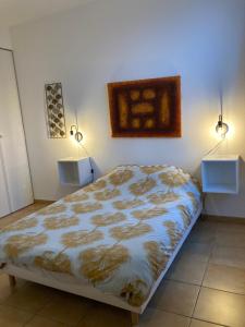 滨海苏拉克La Rosaire的卧室配有一张床,墙上有两盏灯