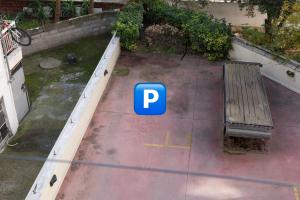 塞萨洛尼基Chris & Mary comfort rooms Thessaloniki center的一个带长凳和蓝色停车标志的停车场