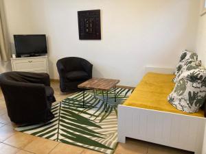滨海苏拉克La Rosaire的一间设有两把椅子、一张桌子和一台电视的房间