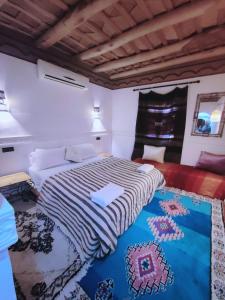 Aït Idaïr拉菲布勒杜达笛斯宾馆的卧室配有一张床,地板上铺有地毯