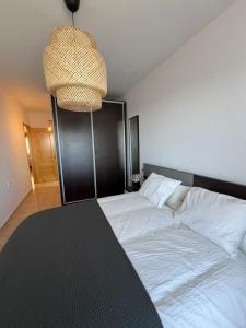 贝莱斯布兰科El Mirador de Velez Blanco的卧室配有一张带吊灯的大型白色床。