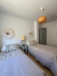 贝莱斯布兰科El Mirador de Velez Blanco的一间卧室配有两张床和两盏灯。