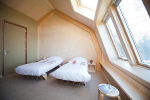 登堡Bed & Coffee Skilleplaatsje的带窗户的客房内的两张床