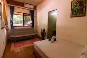 圣卡塔利娜岛Hostel Villa Vento Surf的一间卧室设有床、窗户和沙发