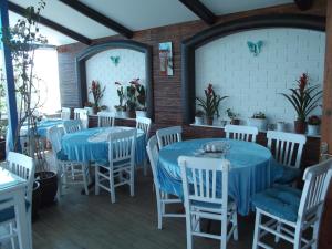 埃尔代克蓝色珍珠公园酒店的一间设有蓝色桌子和白色椅子的餐厅