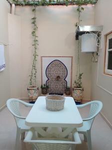 海尼夫拉Maison d'hôte Najah的客房内的白色桌椅