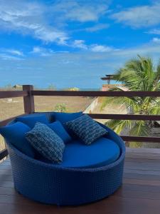 巴拉格兰德Pousada Lá em Casa的海滩景甲板上的蓝色沙发