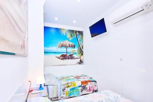 莫切Holidays Beach Torrox - 6的一间设有床铺的客房和一个带遮阳伞的海滩