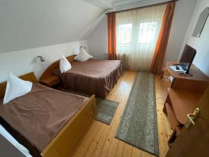 瓦特拉多尔内Pensiunea Genţiana的酒店客房设有两张床和电视。