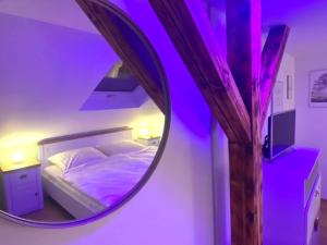 加格瑙Schwarzwaldliebe Ferienwohnung mit eigenem Garten的一间卧室配有圆形镜子和一张床