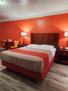卡农城Motel 6-Canon City, CO 719-458-1216的一间卧室配有一张带橙色墙壁的大床