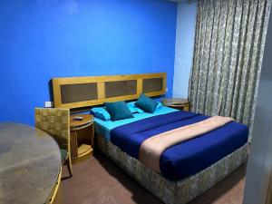 安曼Conord Hotel - "Amman's Heart"的一间卧室配有一张带蓝色墙壁的大床