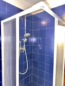 巴多尼奇亚Villa Esclusiva a 3 Piani的浴室设有蓝色瓷砖墙和淋浴。