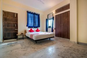 巴特那Flagship Hotel Bihan Hospito India的卧室配有1张特大号床和红色枕头