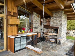 拉兹洛格Villa - VALL DI VALL in Pirin Golf & Country Club的带淋浴和石墙的户外厨房