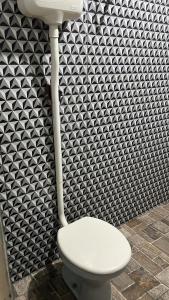 里约布兰科Condomínio luiza的浴室内白色的卫生间,配有黑白壁纸