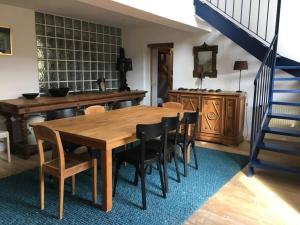 圣阿姆贝尔维尤Lumineuse Et Spacieuse Maison Style Loft的一间带木桌和椅子的用餐室