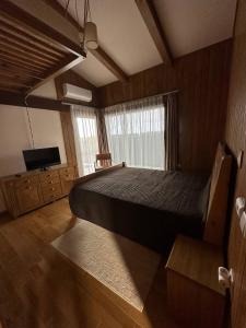 拉兹洛格Villa - VALL DI VALL in Pirin Golf & Country Club的一间卧室配有一张大床和电视