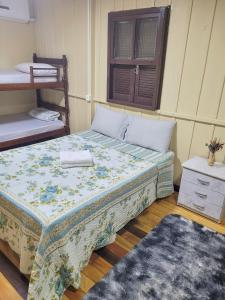 劳鲁米莱Pousada Justi Oliveira的一间卧室配有一张床和一张双层床,铺有地毯。