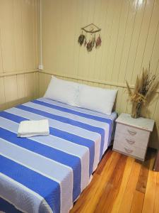 劳鲁米莱Pousada Justi Oliveira的一间卧室配有一张蓝色和白色条纹的床