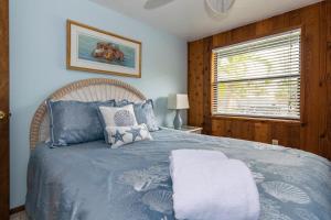 安娜玛丽亚Azure Seas的一间卧室配有一张带蓝色床单的床和一扇窗户。