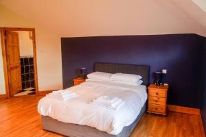 CloneenThe Mountain Lodge Slievenamon spacious 4 bedroom house的一间卧室配有一张白色大床和蓝色的墙壁