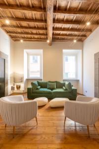 罗马Fontana di Trevi Roma Luxury Suite的客厅配有绿色沙发和两把椅子
