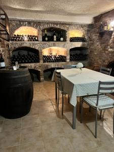 蒙卡尔沃Cascina il Volo的酒窖配有桌椅和葡萄酒瓶
