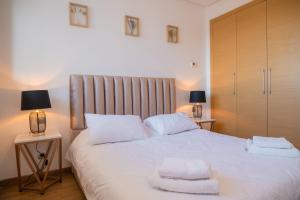 拉巴特Appartement luxueux Prestigia的卧室配有白色的床和2条毛巾
