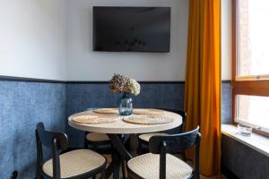 波兹南Homewell Apartments Czartoria- free parking的一张桌子、椅子和一个花瓶