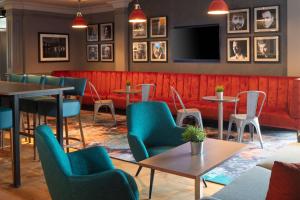 英格里斯顿爱丁堡机场希尔顿逸林酒店的餐厅设有桌椅和平面电视。