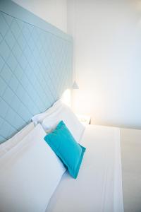 滨海波利尼亚诺皮埃特拉布鲁Spa度假酒店 - CDS酒店的卧室配有白色床和蓝色枕头