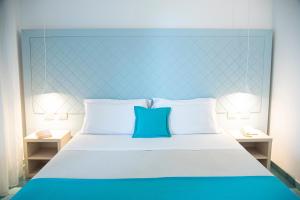 滨海波利尼亚诺皮埃特拉布鲁Spa度假酒店 - CDS酒店的一张带蓝色床头板和2个床头柜的床
