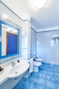 滨海波利尼亚诺皮埃特拉布鲁Spa度假酒店 - CDS酒店的蓝色的浴室设有水槽和卫生间