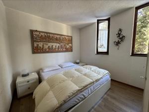 摩德纳迪-坎皮格里奥Appartamento Patascoss的卧室配有一张床,墙上挂着一幅画