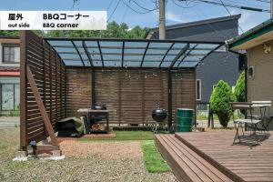 富士吉田市Fujisan Guest House Kikkaya - Vacation STAY 28692v的一个带烧烤架和木甲板的庭院