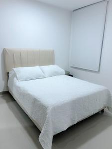 巴耶杜帕尔Apartaestudio Amoblado的白色卧室内的白色床和白色床罩