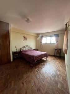 拉巴斯The Hidden House Hostel的一间卧室配有一张床,铺有木地板