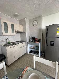 卡塔赫纳FRAGATA STYLE 2的厨房配有不锈钢冰箱和时钟