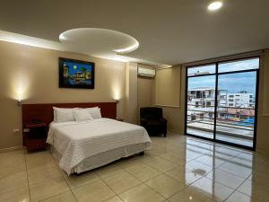 曼塔冒险家酒店的一间卧室设有一张床和一个大窗户