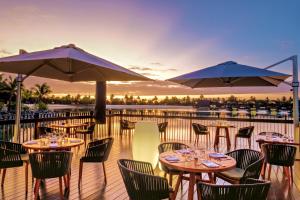 Momi斐济莫米湾万豪度假酒店的甲板上设有桌子和遮阳伞的餐厅