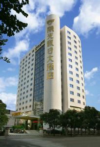 福州福建阳光假日大酒店的一座白色的大建筑,上面有标志