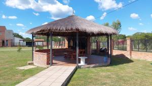 YpacaraiLugar de descanso ideal, Paraiso al lago, Ypacarai - Central的田野上带草屋顶的凉亭