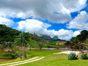 佩德拉阿祖尔Pousada Rural Recanto do Lago的一个带湖泊和凉亭的公园